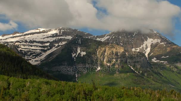 Wolken ziehen über dunklen Berg und grünes Tal — Stockvideo