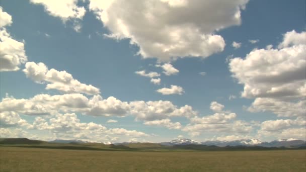 Pan de cielos azules anchos y montañas distantes — Vídeo de stock