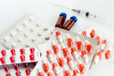 Hap, kapsül, vitaminler, şırınga ve ampul beyaz bir arka plan üzerinde