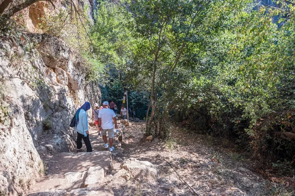 Pessoas descendo escadas de pedra em direção a caverna do Abismo do Céu no distrito de Silifke, Mersin — Fotografia de Stock