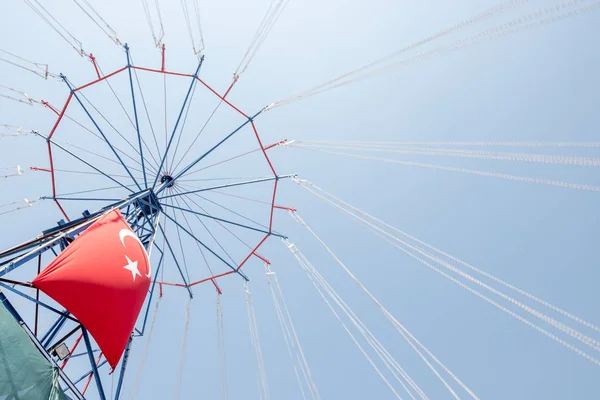Yolculuk (zincir salıncak carousel) sallanan ve Türk bayrağı asılı. — Stok fotoğraf