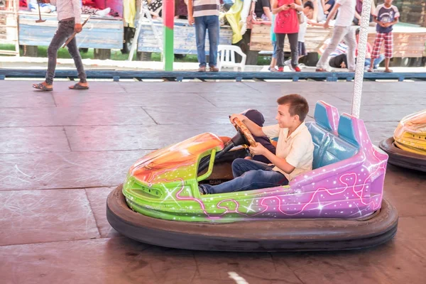 Crianças e crianças se divertindo no parque de diversões — Fotografia de Stock