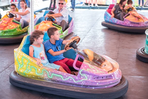 Crianças e crianças se divertindo no parque de diversões — Fotografia de Stock