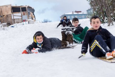 Çocuk Istanbul.Happiness ve sevinç kavram parke kızak ile eski okul tarzı karda kaydırın. Istanbul,Turkey.31 Aralık, 2015