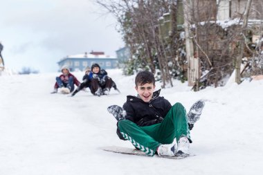 Çocuk Istanbul.Happiness ve sevinç kavram parke kızak ile eski okul tarzı karda kaydırın. Istanbul,Turkey.31 Aralık, 2015