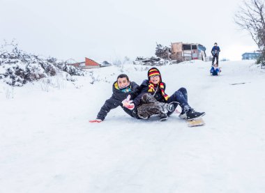 Çocuk Istanbul.Happiness ve sevinç kavram parke kızak ile eski okul tarzı karda kaydırın. Istanbul,Turkey.31 Aralık, 2015