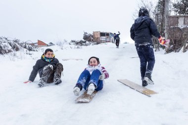 Çocuk Istanbul.Happiness ve sevinç kavram parke kızak ile eski okul tarzı karda kaydırın. Istanbul,Turkey.31 Aralık, 2015