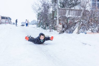 Çocuk Istanbul.Happiness ve sevinç kavram parke kızak ile eski okul tarzı karda kaydırın. Istanbul,Turkey.31 Aralık, 2015