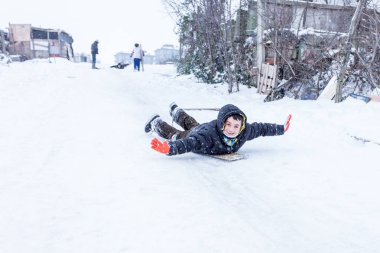 Çocuk Istanbul.Happiness ve sevinç kavram parke kızak ile eski okul tarzı karda kaydırın. Istanbul,Turkey.31 Aralık, 2015
