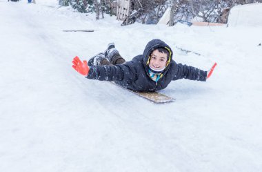 Çocuk Istanbul.Happiness ve sevinç kavram parke kızak ile eski okul tarzı karda kaydırın. Istanbul,Turkey.31 Aralık, 2015