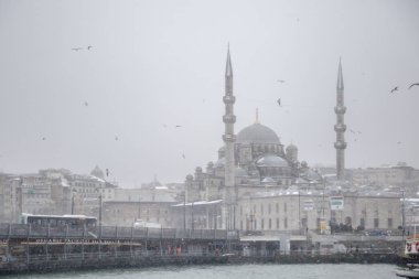 Kışın karlı bir günde boğaz popüler yeni Mosgue ve Galata Bridge.Seagulls uçmaktan kış deniz manzarası görünümü.