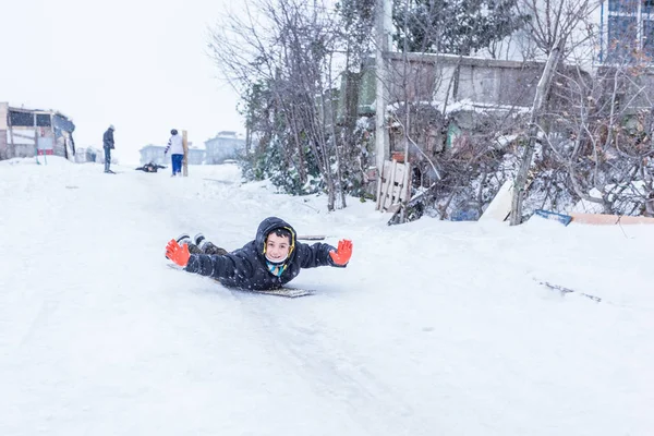 Çocuk Istanbul.Happiness ve sevinç kavram parke kızak ile eski okul tarzı karda kaydırın. Istanbul,Turkey.31 Aralık, 2015