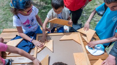 Kimliği belirsiz çocuk geleneksel Türk ahşap puzzle oyna. Etnospor Kültür Festivali bileziğinde bulunmakta. Istanbul, Türkiye, 13,2017 olabilir