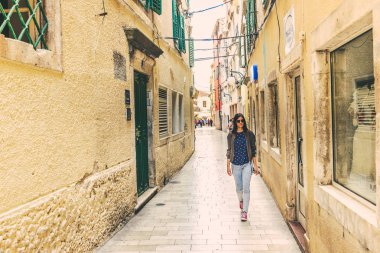 Kimliği belirsiz kız Sibenik Street, tarihi mimari, popüler seyahat hedef, yürüyüş Croatia.May 26,2017 taş sokakları dar