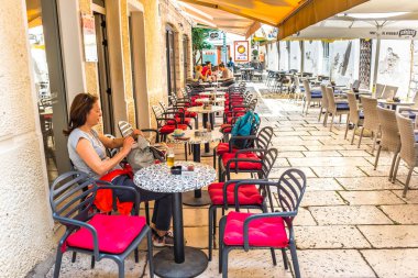 Kimliği belirsiz bir kadın içki bira Sibenik, popüler seyahat hedef tarihi mimarisi için Café Croatia.May 26,2017 taş sokakları dar