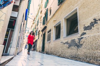 Kimliği belirsiz kız Sibenik Street, tarihi mimari, popüler seyahat hedef, yürüyüş Croatia.May 26,2017 taş sokakları dar