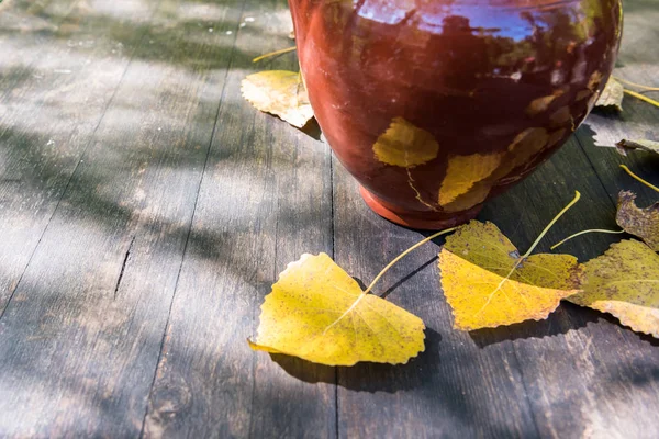 秋天寂静的生活瓦罐和黄色叶子在蓝色 褐色老桌 — 图库照片
