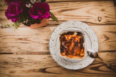 Türk geleneksel pirinç, süt pudingler; sutlac, çiçeklerle ahşap bir vintage masaya servis