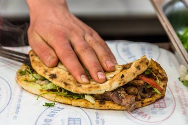 Adam el hazırlanıyor lezzetli karaciğer Türk şiş kebap ızgara silindir Mini değirmenler hizmet üzerinde.