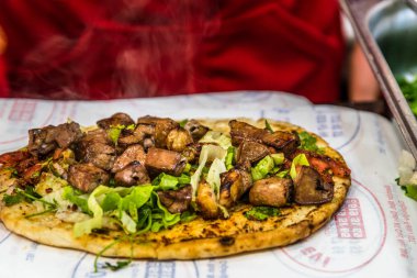 Adam el hazırlanıyor lezzetli karaciğer Türk şiş kebap ızgara silindir Mini değirmenler hizmet üzerinde.