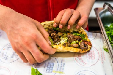 Adam el hazırlanıyor lezzetli karaciğer Türk şiş kebap ızgara silindir Mini değirmenler hizmet üzerinde.