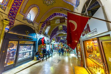 Kimliği belirsiz turist ziyaret ve Kapalıçarşı Istanbul'da alışveriş. Türk bayrağı ile kapalı çarşı iç ön plan üzerinde. Istanbul, Turkey.April 17, 201