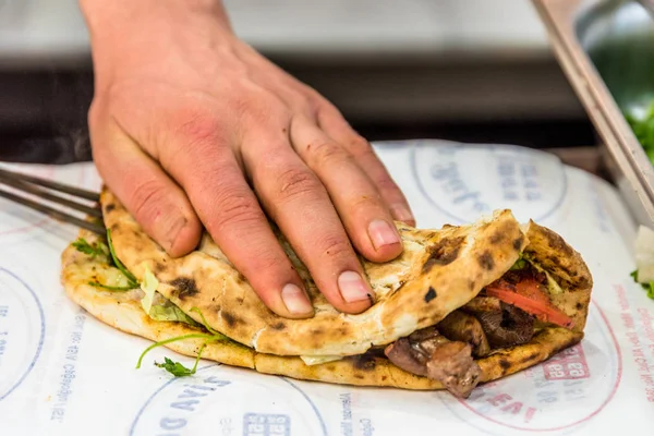 Adam el hazırlanıyor lezzetli karaciğer Türk şiş kebap ızgara silindir Mini değirmenler hizmet üzerinde.