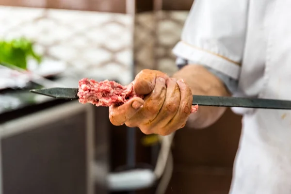 ラムのレバーは 伝統的なおいしいトルコ シシカバブ串焼きを準備する男の手 — ストック写真