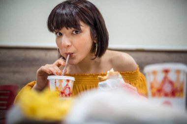 Şirin kız fast food yapan bir kafede oturuyor.