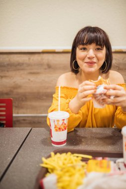 Şirin kız fast food yapan bir kafede oturuyor.
