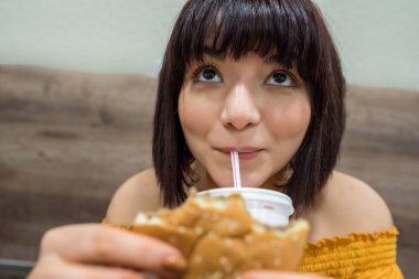 Şirin kız fast food yapan bir kafede oturuyor.