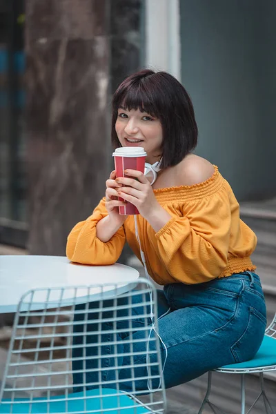 Красивая девушка с кружкой кофе в кафе — стоковое фото