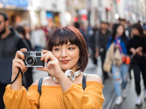 Симпатичная девушка снимает фоты на ретро-винтажную камеру. — стоковое фото