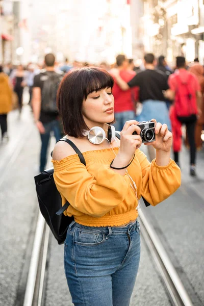 Симпатичная девушка снимает фоты на ретро-винтажную камеру. — стоковое фото