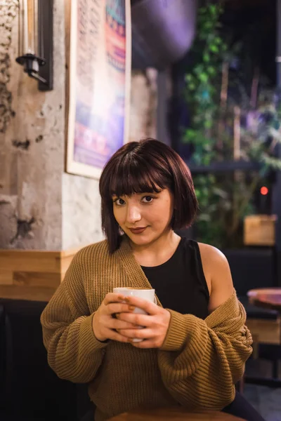 Вид симпатичной девушки, сидящей в кафе — стоковое фото