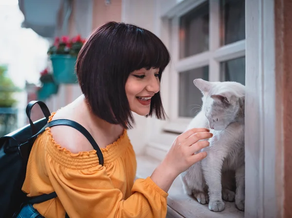 Cute girl loves a white street cat