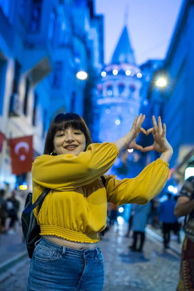 Mooie vrouw maakt hart vorm in de voorkant van Galata toren — Stockfoto