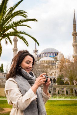 İstanbul, Türkiye 'de turistler ve turistler için popüler bir yer olan Sultanahmet Camii veya Mavi Cami manzaralı güzel bir kadın turist fotoğrafı çekti