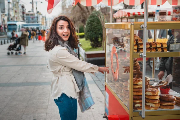 Симпатичная девушка показывает турецкий уличный фаст-фуд симит — стоковое фото