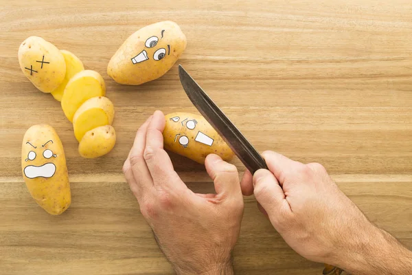 Wajah menakutkan kentang yang dipotong di papan dapur kayu — Stok Foto