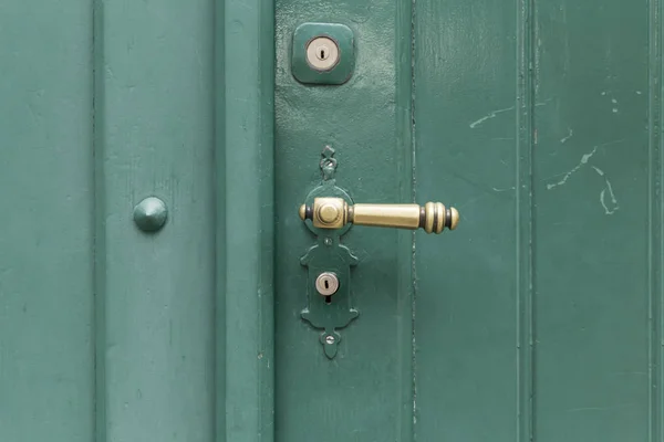 Porta de madeira pintada verde com botão dourado reto — Fotografia de Stock