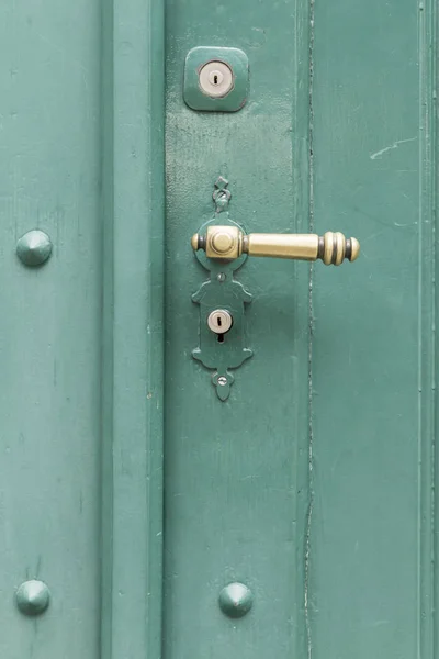 Porta de madeira pintada verde com botão dourado reto — Fotografia de Stock