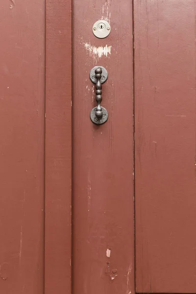 Red painted wooden door with straight metal knob