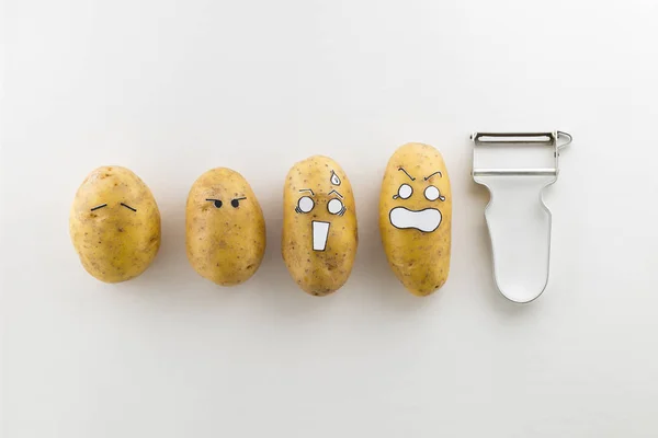 Wajah menakutkan kentang dan pengupas pada latar belakang putih — Stok Foto