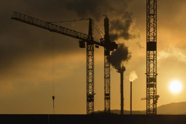 İnşaat site Vinçler ve baca siluetleri