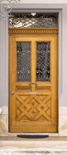 Красивые резные коричневые деревянные двери с металлической сеткой — стоковое фото