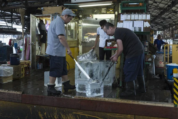 Werknemers het snijden van ijsblokken op de Tokyo Tsukiji Vismarkt in Japan — Stockfoto