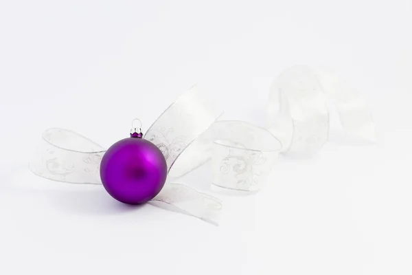 Schöne lila Weihnachtskugeln mit weißer Schleife — Stockfoto
