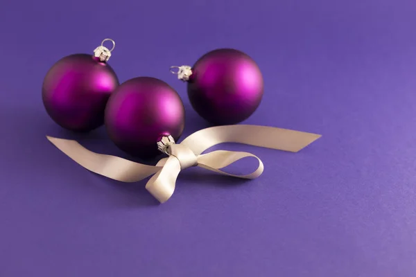 Фіолетові різдвяні кульки з сірою стрічкою — стокове фото