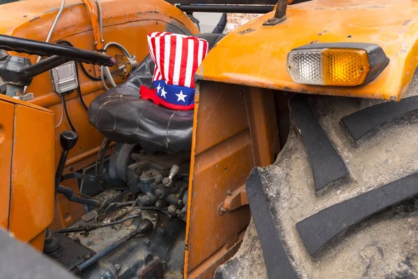 Апельсиновый трактор в шляпе дяди Сэма — стоковое фото